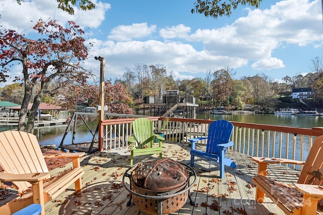 deck with a water view and a fire pit