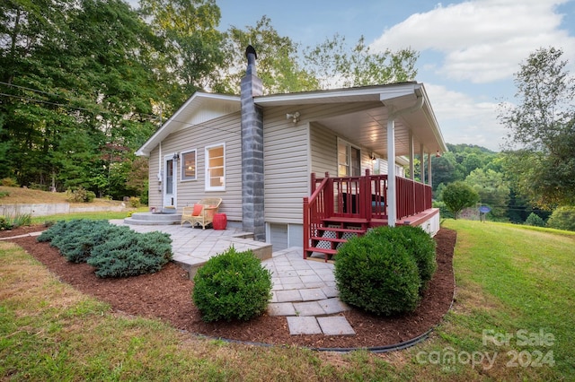 view of side of home with a lawn and a patio