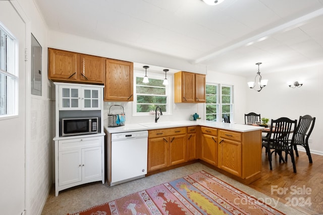 kitchen with white dishwasher, an inviting chandelier, decorative light fixtures, sink, and kitchen peninsula