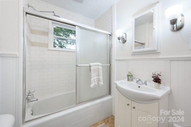 full bathroom featuring vanity, toilet, and bath / shower combo with glass door