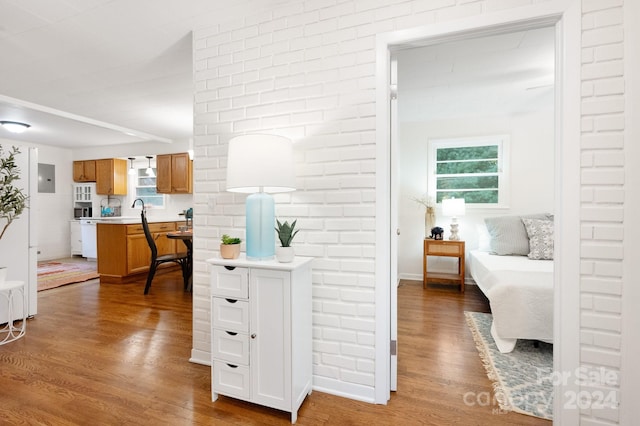 corridor with hardwood / wood-style flooring and electric panel