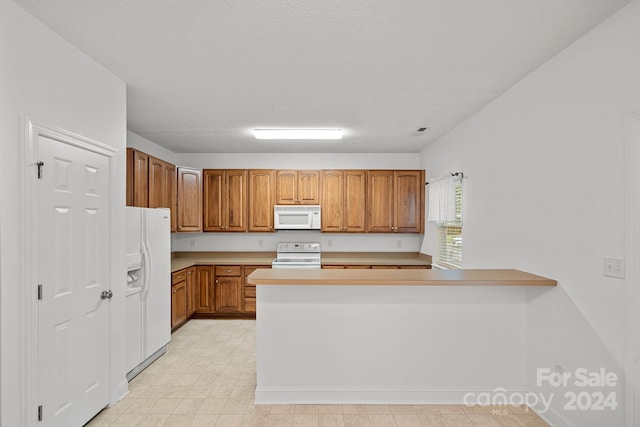 kitchen featuring white appliances, kitchen peninsula, and a textured ceiling