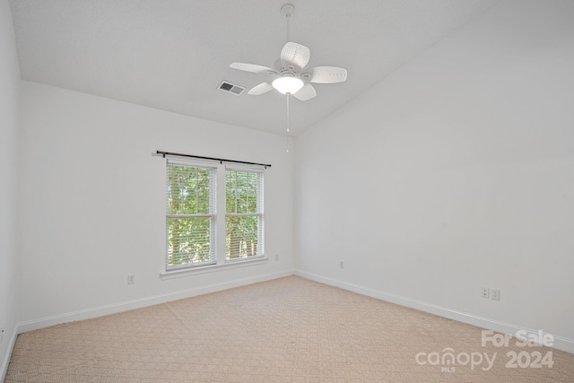 carpeted empty room featuring ceiling fan and vaulted ceiling