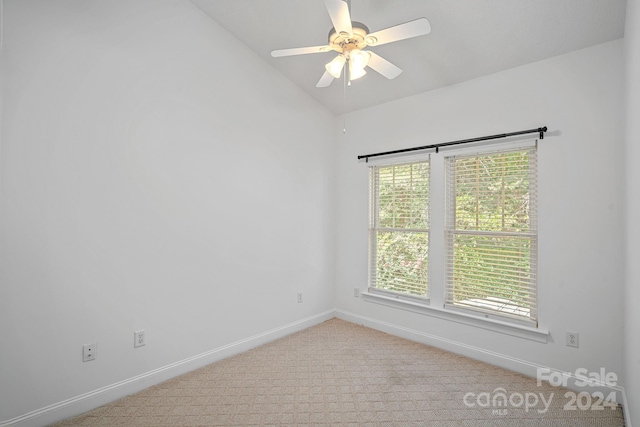 carpeted spare room featuring ceiling fan and vaulted ceiling