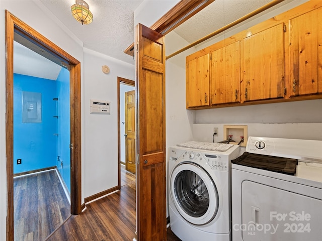 laundry area featuring dark hardwood / wood-style flooring, a textured ceiling, cabinets, washer and clothes dryer, and electric panel