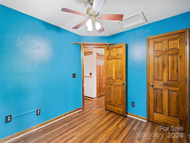 unfurnished bedroom with ceiling fan and dark wood-type flooring