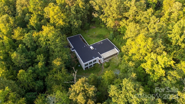 birds eye view of property featuring a forest view