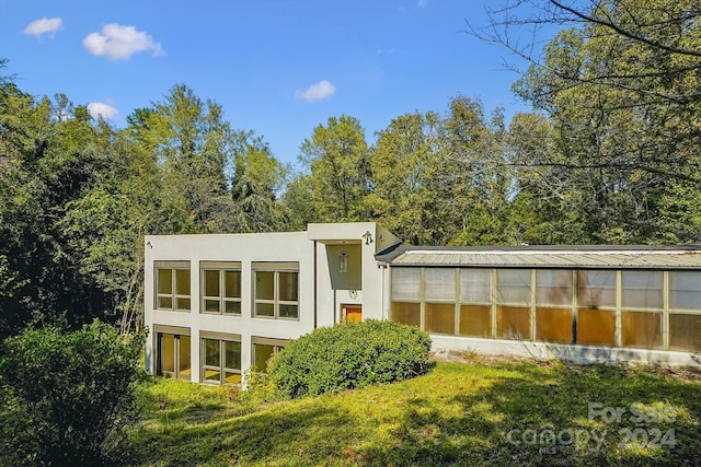 rear view of property with a sunroom and a yard