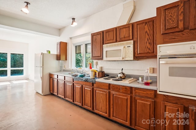 kitchen with sink, white appliances, and a textured ceiling