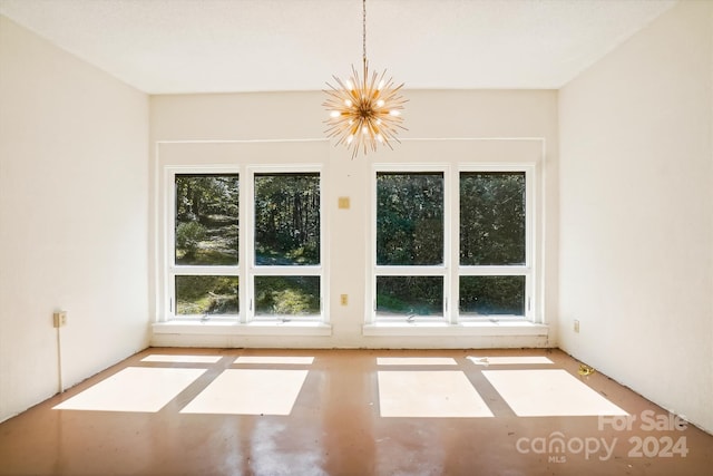 empty room with plenty of natural light and a notable chandelier