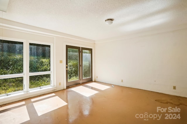 unfurnished room featuring concrete floors and a textured ceiling