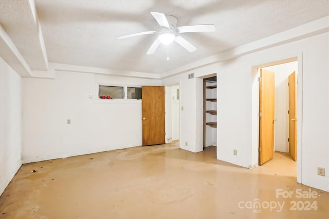 unfurnished bedroom featuring ceiling fan and a textured ceiling