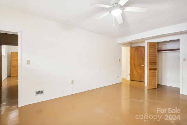 unfurnished bedroom featuring concrete flooring, ceiling fan, and a closet