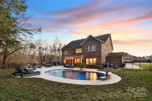 back house at dusk featuring a fenced in pool, a yard, outdoor lounge area, and a patio