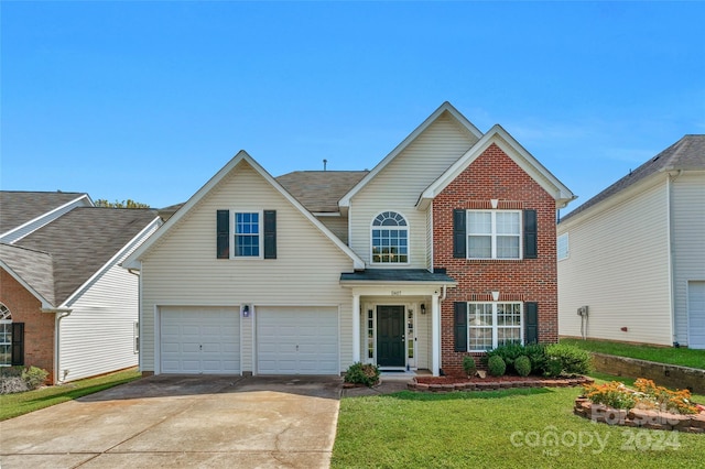 traditional home featuring driveway, an attached garage, a front lawn, and brick siding