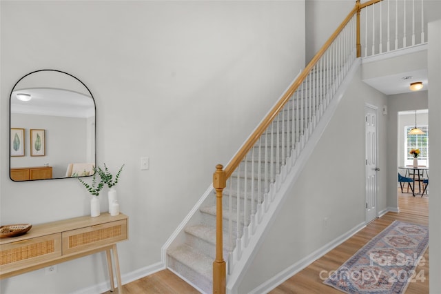 stairs featuring wood finished floors and baseboards