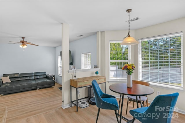 dining room with light wood-style flooring, a ceiling fan, visible vents, and baseboards