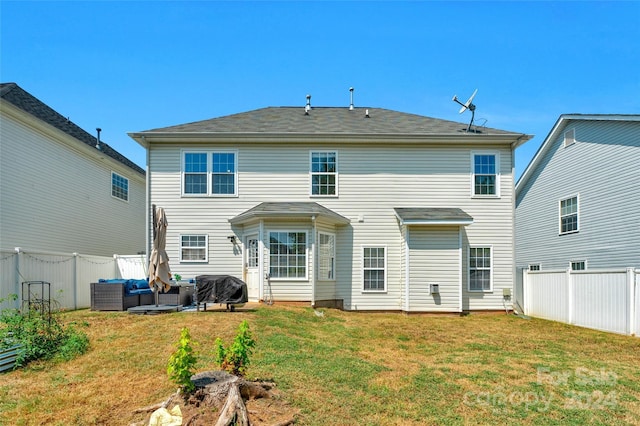 rear view of property with a fenced backyard, a lawn, and outdoor lounge area