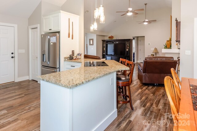 kitchen featuring stainless steel fridge, ceiling fan, dark hardwood / wood-style floors, black electric cooktop, and white cabinets