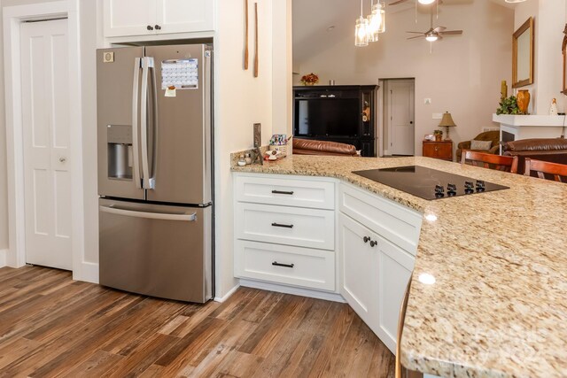 kitchen with white cabinetry, stainless steel fridge, wood-type flooring, black electric cooktop, and ceiling fan