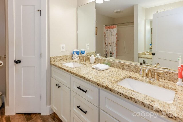 bathroom featuring toilet, walk in shower, hardwood / wood-style flooring, and vanity