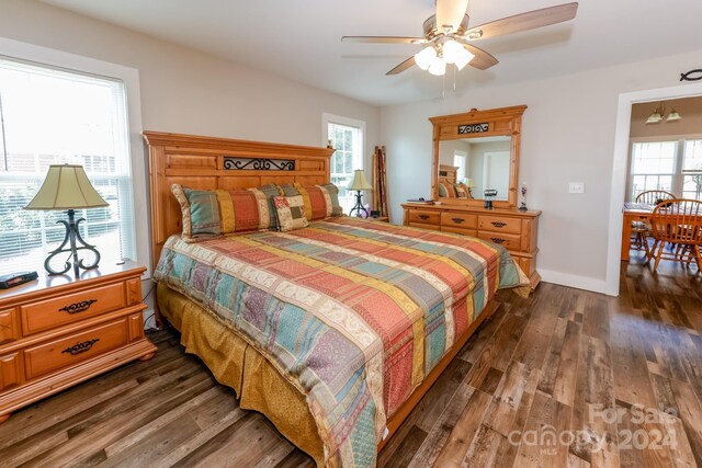 bedroom with dark hardwood / wood-style floors and multiple windows