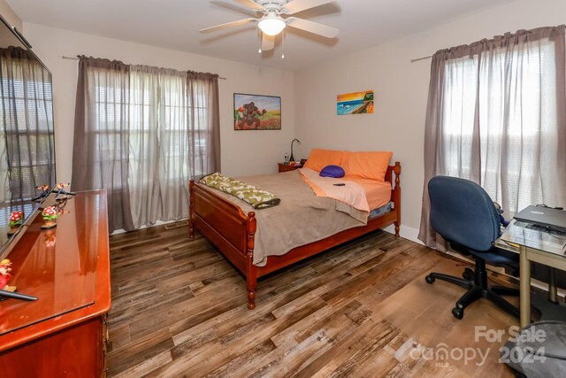 bedroom featuring multiple windows, ceiling fan, and dark hardwood / wood-style floors