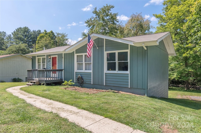 single story home featuring a front yard and a deck