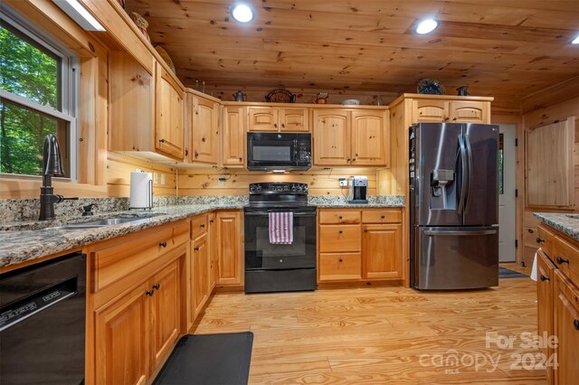 kitchen featuring light hardwood / wood-style flooring, black appliances, sink, light stone countertops, and wood ceiling