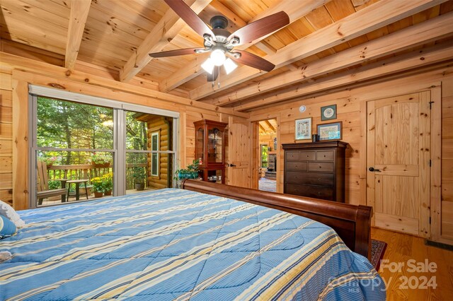 bedroom featuring beamed ceiling, wood ceiling, hardwood / wood-style flooring, ceiling fan, and wooden walls