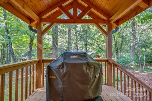 wooden deck with a gazebo and area for grilling