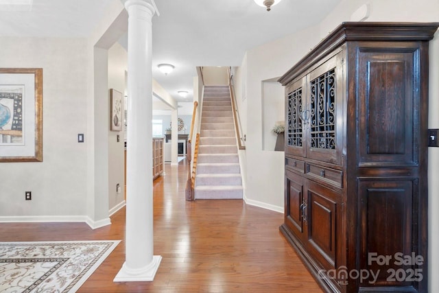 foyer featuring hardwood / wood-style flooring and ornate columns