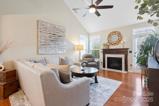 living room featuring hardwood / wood-style flooring, high vaulted ceiling, and ceiling fan