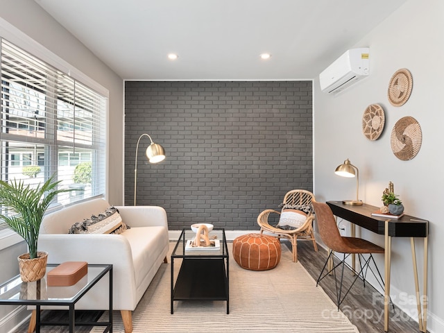 living area with brick wall, hardwood / wood-style floors, a wealth of natural light, and a wall mounted AC