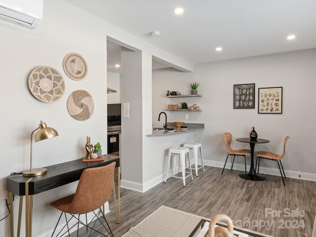 bar featuring dark hardwood / wood-style flooring, stainless steel stove, a wall mounted AC, and sink