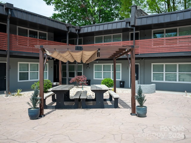 rear view of property featuring a pergola