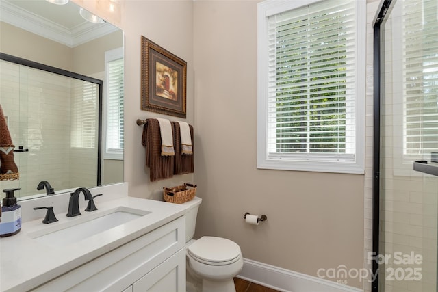 bathroom featuring toilet, tiled shower, crown molding, baseboards, and vanity