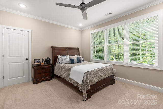 carpeted bedroom with ornamental molding and ceiling fan