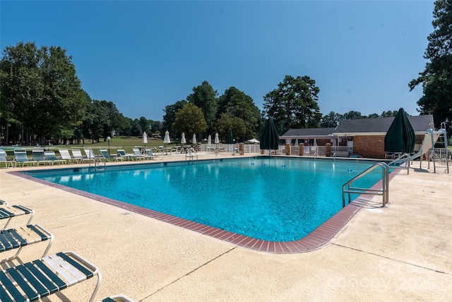 pool with a patio and a water slide