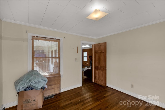 empty room with dark wood-type flooring and ornamental molding