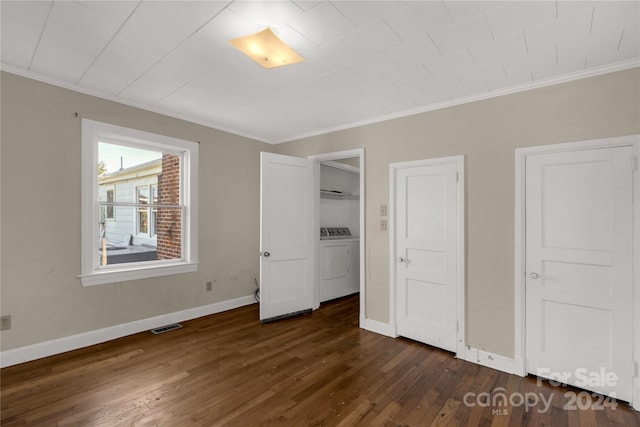 unfurnished bedroom featuring washing machine and clothes dryer, dark wood-type flooring, and crown molding