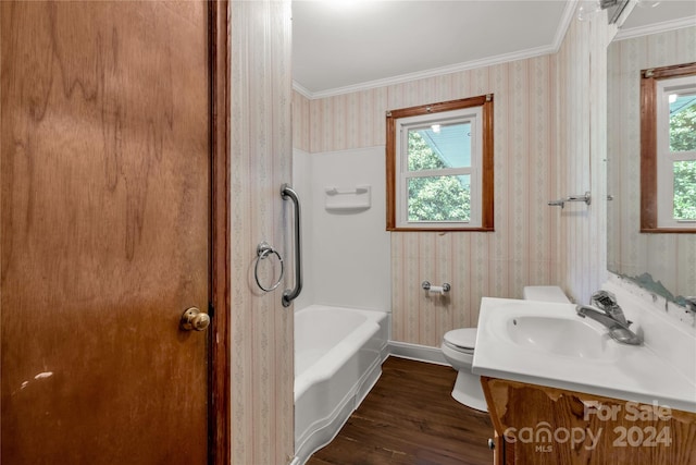 bathroom with a tub to relax in, a healthy amount of sunlight, toilet, and wood-type flooring