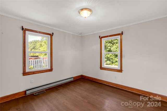 spare room with baseboard heating, dark hardwood / wood-style flooring, and crown molding