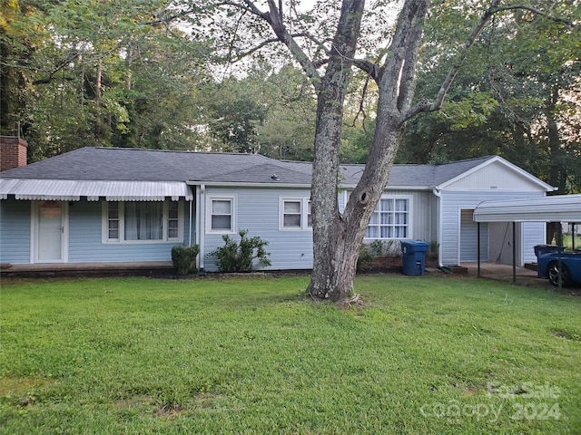 ranch-style home with a front yard and a carport