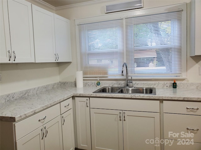 kitchen featuring ornamental molding, sink, and white cabinetry