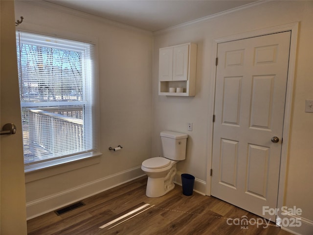 bathroom with crown molding, toilet, and hardwood / wood-style flooring