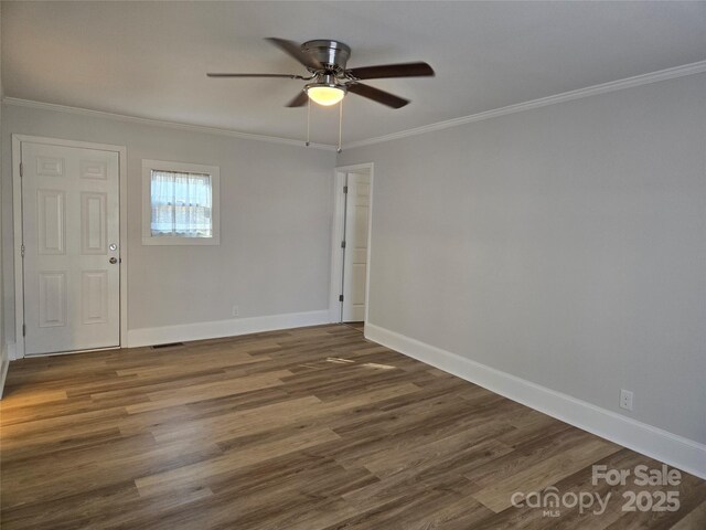 unfurnished room featuring crown molding, ceiling fan, and dark wood-type flooring