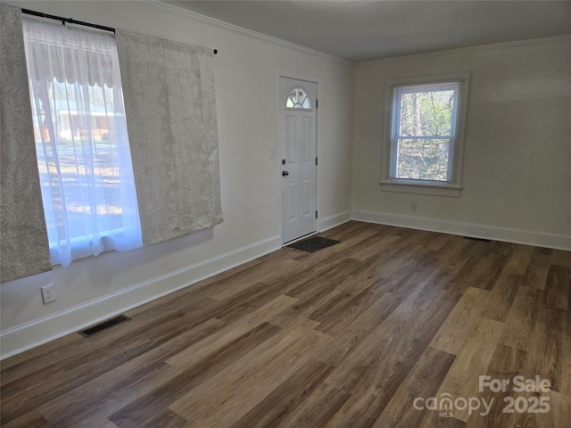 foyer entrance with crown molding and dark hardwood / wood-style floors