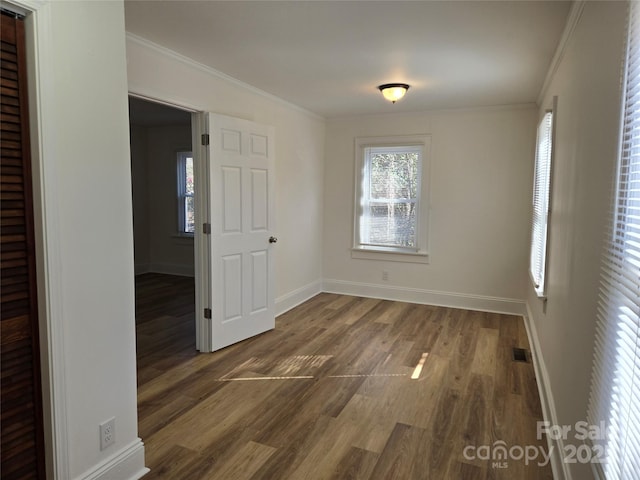 unfurnished room with crown molding and dark hardwood / wood-style flooring