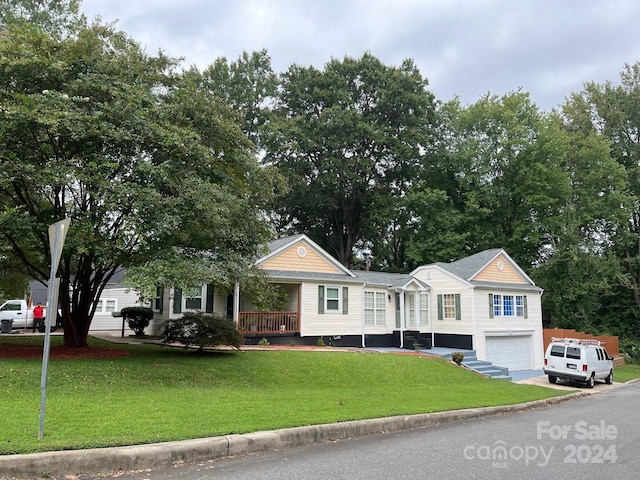 view of front facade featuring a garage, a porch, a front lawn, and driveway